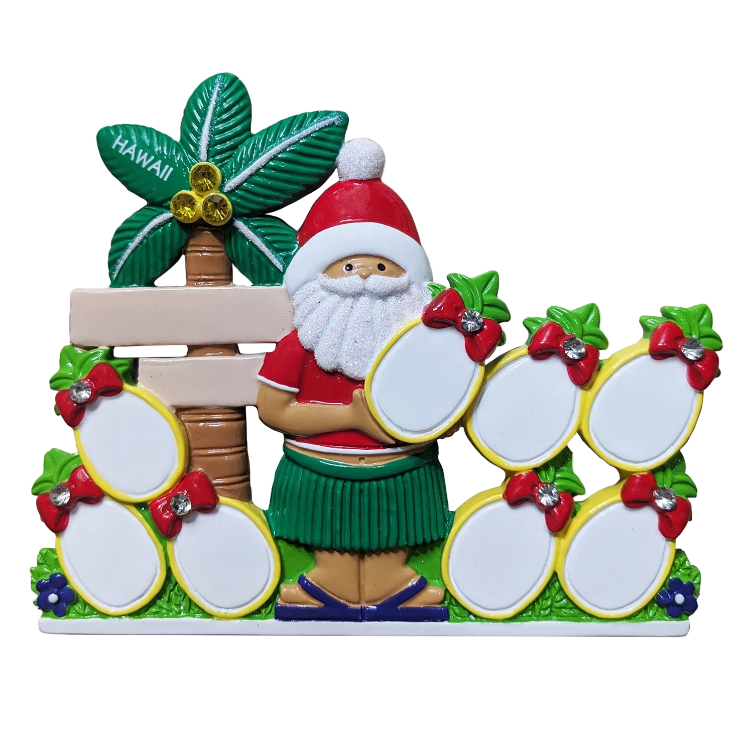 A colorful Santa Claus-themed decorative plaque or table topper with a green Hawaiian hula skirt, red hat, white beard, a palm tree labeled Hawaii, and multiple pineapple slots for personalizing in yellow with red bow details.